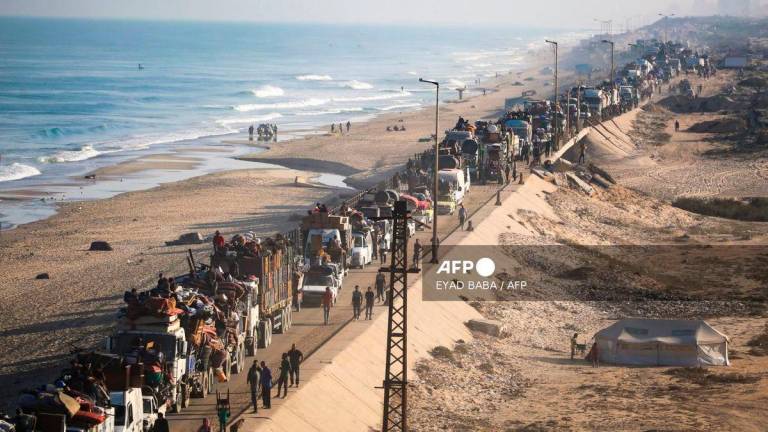 Displaced Palestinians move with their belongings southwards on a road in the Nuseirat refugee camp area in the central Gaza Strip following renewed Israeli evacuation orders for Gaza City on September 18, 2025. - AFP