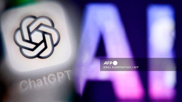 (FILES) A photo taken on September 1, 2025 shows the letters AI for Artificial Intelligence on a laptop screen (R) next to the logo of the ChatGPT application on a smartphone screen in Frankfurt am Main, western Germany. - AFP