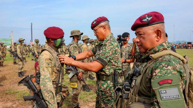 Timbalan Penglima Tentera Darat, Leftenan Jeneral Datuk Tengku Muhammad Fauzi Tengku Ibrahim (tengah) melakukan ucapara penganugerahan beret merun dan sayap berdarah kepada anggota pada Majlis Penutup Kursus Asas Pasukan Aturgerak Cepat (APAC) Siri 2/2025 di Dataran Drawbridge, hari ini- BERNAMA