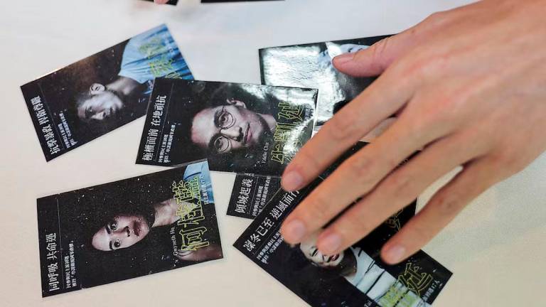 Sky Fung, Secretary-General, Hong Kong Outlanders, shows cards with pictures of activists as he holds a press conference in Taipei, Taiwan November 20, 2024. REUTERS/Ann Wang/File photo