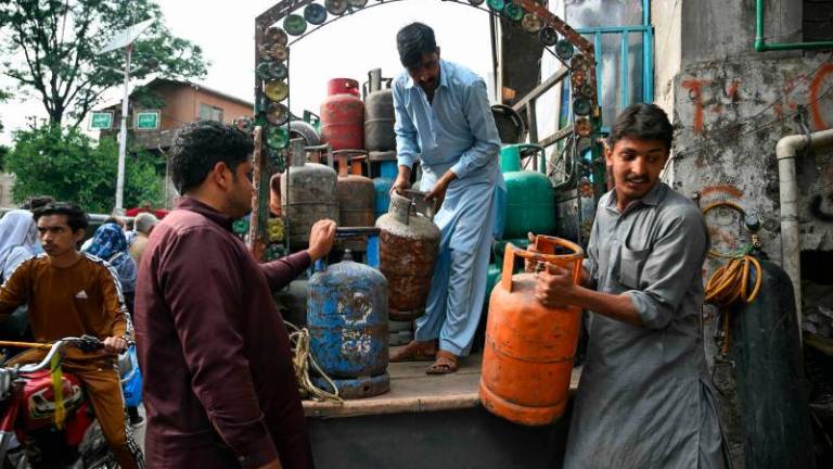 Shopkeepers unload gas cylinders at a market in Muzaffarabad on May 2, 2025. AFPpix