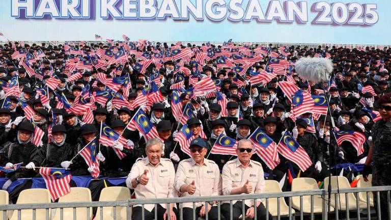 Perdana Menteri Datuk Seri Anwar Ibrahim (tengah) bersama kedua-dua Timbalan Perdana Menteri Datuk Seri Dr Ahmad Zahid Hamidi (kiri) dan Datuk Seri Fadillah Yusof (kanan) bergambar kenangan bersama para pelajar yang membuat persembahan grafik manusia selepas Sambutan Hari Kebangsaan 2025 di Dataran Putrajaya hari ini -fotoBERNAMA