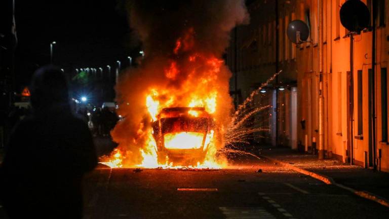 A vehicle is set alight during an anti-immigration demonstration in Ballymena, Northern Ireland, on June 10, 2025. (Photo by PAUL FAITH / AFP)