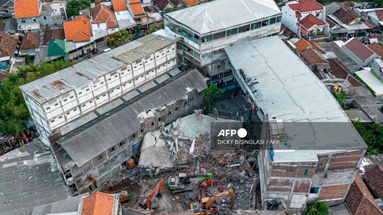 Rescuers searching for victims at the Al Khoziny Islamic boarding school in Sidoarjo, East Java, on October 5, 2025. (Photo by Dicky Bisinglasi / AFP)