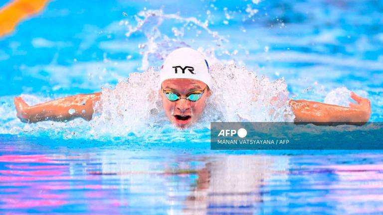 France’s swimmer Leon Marchand competes in a heat of the men’s 400m individual medley swimming event during the 2025 World Aquatics Championships in Singapore on August 3, 2025. (Photo by MANAN VATSYAYANA / AFP)