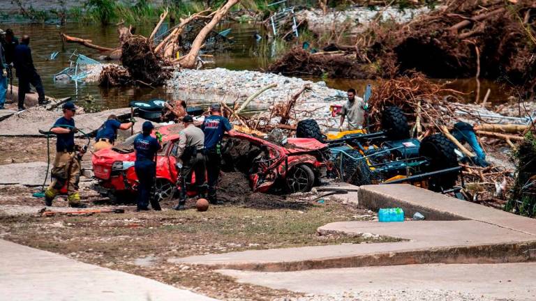 First responders attend to a vehicle pulled from the water in the aftermath of deadly flooding in Kerrville, Texas, U.S., July 6, 2025. - REUTERS/Sergio Flores
