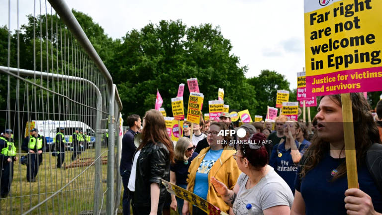 Protestors hold placards reading Far right are not welcome in Epping as they face an anti-immigrant demonstration in front of The Bell Hotel believed to be housing asylum seekers, in Epping, northest of London, on July 27, 2025. - AFP