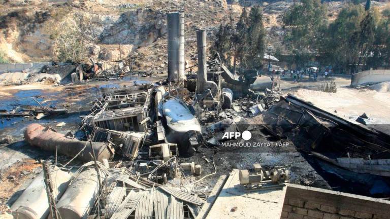 People inspect the damage at a cement manufacturing complex a day after a series of Israeli airstrikes in the southern Lebanese village of Ansar on October 17, 2025. - AFP