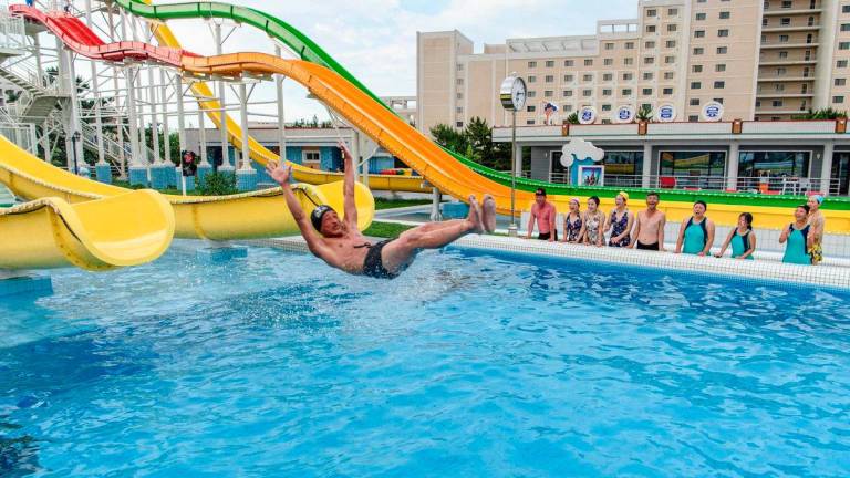 Domestic tourists watch as a man uses a slide into a swimming pool at the Myongsasimni Water Park in the Wonsan Kalma Coastal Tourist Area in Wonsan, North Korea’s Kangwon Province - AFPPix