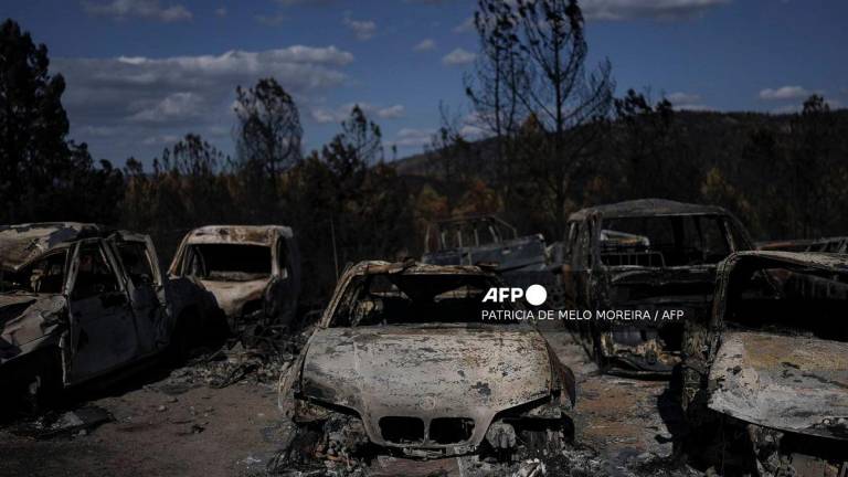Burnt cars are pictured at the car stand and garage “AntasCar” during a wildfire in Sarzeda village in Trancoso, Portugal on August 20, 2025. - PATRICIA DE MELO MOREIRA / AFP