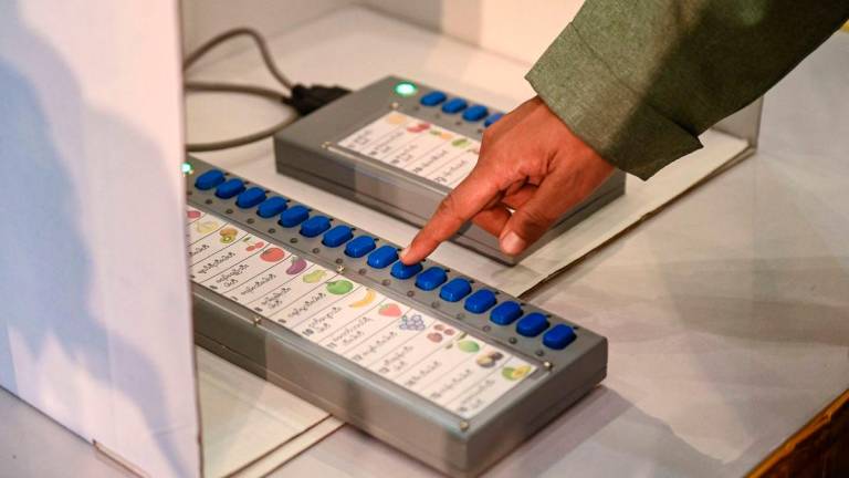 (FILES) An official shows how to use a voting machine for future elections in Yangon on September 5, 2023. Myanmar’s ruling military junta said on August 18, 2025 that the country’s election will start on December 28, beginning a phased poll being boycotted by opposition groups and criticised by international monitors. (Photo by AFP)