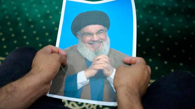 An Iraqi volunteer holds a picture of Lebanon’s Hezbollah leader Sayyed Hassan Nasrallah, who has been killed - REUTERSpix