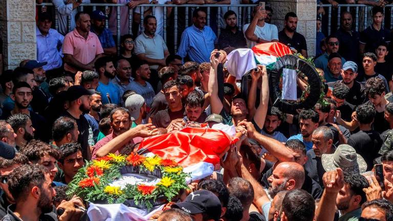Mourners carry the bodies of dual US-Palestinian citizen Saif al-Din Kamil Abdul Karim Musalat and Palestinian Mohammad al-Shalabi during their funeral at the Palestinian village of Al-Mazraa Al-Sharqiya in the occupied West Bank on July 13, 2025, after they were reportedly killed by Israeli settlers two days prior. - Zain JAAFAR / AFP