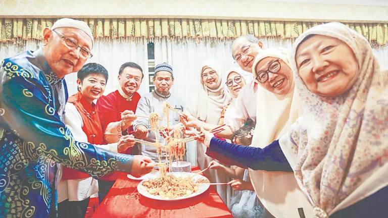 Macma members tossing a serving of ‘Yee Sang’ during the event on Sunday. – ADAM AMIR HAMZAH/THESUN