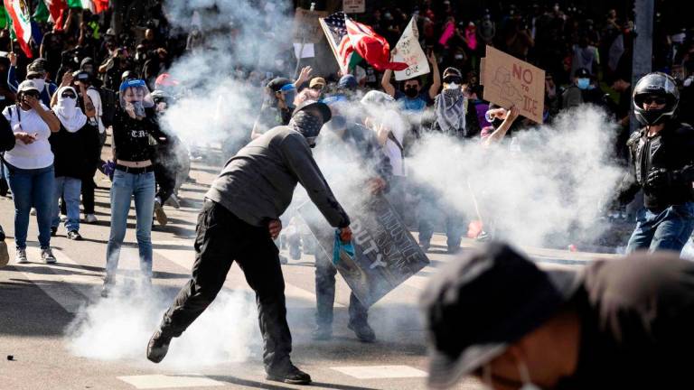 A demonstrator throws a tear gas canister back at law enforcement during clashes that erupted after authorities declared an unlawful assembly during the “No Kings” protest against the Trump administration in Los Angeles on June 14, 2025. APFpix