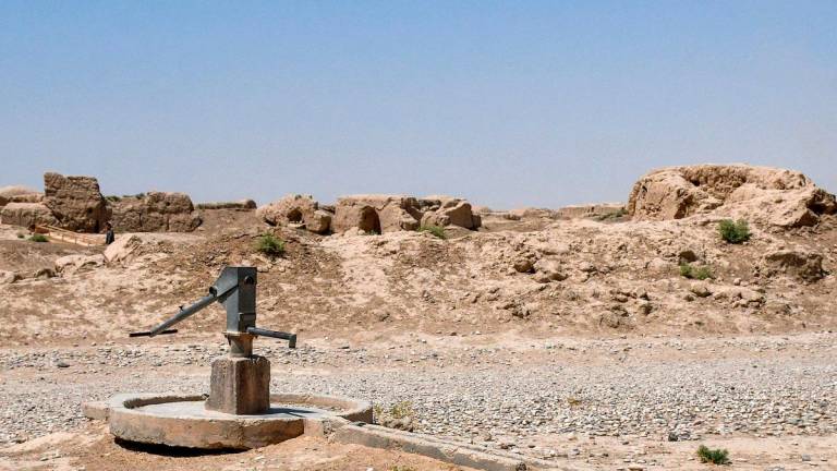 This photograph taken on July 10, 2025 shows a hand pump near dilapidated dome-shaped traditional Afghan houses on a deserted street as chronic water scarcity stalks the drought-ridden village of Bolak in the Chahar Bolak district at Balkh province. - Atif Aryan / AFP