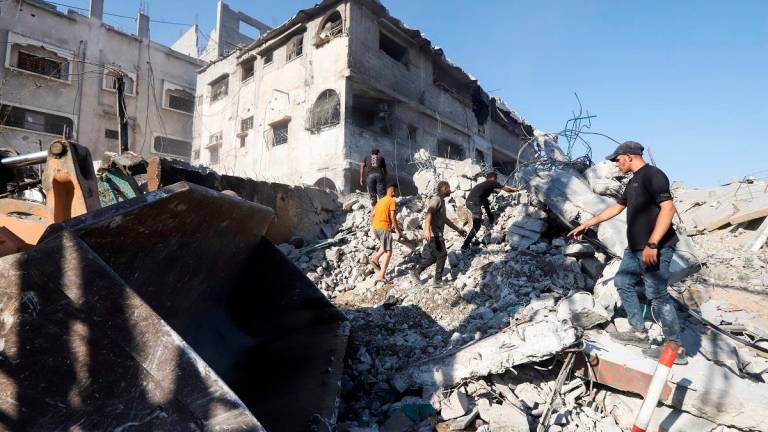 Palestinians search for casualties at the site of an overnight Israeli strike on a fuel station where displaced people shelter, in Gaza City, June 25, 2025. - REUTERS/Khamis Al-Rifi