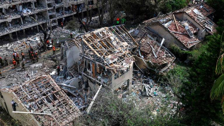 Israeli security forces and first responders gather at the site of an Iranian strike that hit a residential neighbourhood in the Ramat Aviv area in Tel Aviv on June 22, 2025. At least 16 people were hurt and at least one impact was reported in central Israel after Iran launched two waves of missiles at the country following the US bombing of its nuclear sites, rescue services and reports said. - AHMAD GHARABLI / AFP