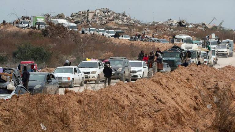 Palestinians wait to cross through a checkpoint run by U.S. and Egyptian security contractors after Israeli forces withdrew from the Netzarim Corridor, allowing people to travel in both directions between southern and northern Gaza, amid a ceasefire between Israel and Hamas, near Gaza City, February 9, 2025. - REUTERSPIX