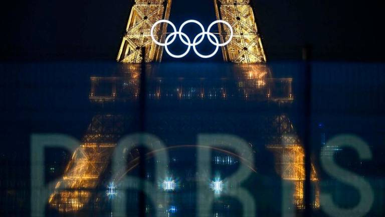 This photograph shows the Eiffel Tower bearing the Olympics rings, lit-up ahead of the Paris 2024 Olympic and Paralympic games - AFPpix