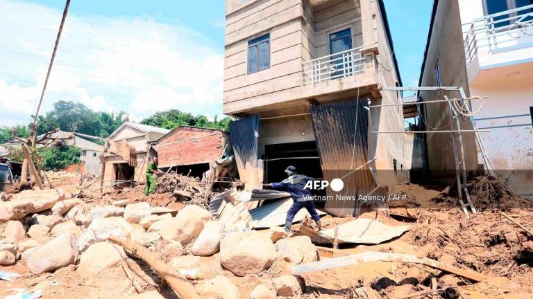 This photo taken by the Vietnam News Agency (VNA) on July 28, 2025 shows rescue workers clearing debris following flash floods in Son La province in northern Vietnam. A weekend flashflood in Vietnam's mountainous north killed five people and another remains missing, authorities said July 29. - AFP PHOTO / VIETNAM NEWS AGENCY