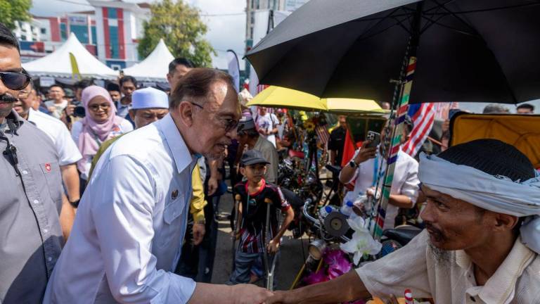 Perdana Menteri Datuk Seri Anwar Ibrahim bersalaman dengan pengayuh beca pada Program MADANI Rakyat (PMR) 2025 Kelantan di perkarangan Stadium Sultan Muhammad IV, hari ini- BERNAMA