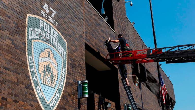 Members of the FDNY place a bunting outside the 47th precinct, which was the police station for the New York Police Department’s Didarul Islam who was killed in the deadly mass shooting, honoring him at the precinct in the Bronx borough of New York City - Reuterspix