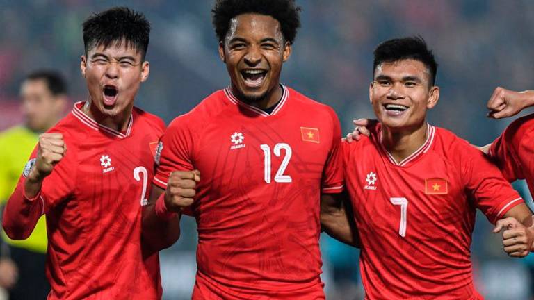 (L-R) Vietnam's Duy Manh Do, Xuan Son Nguyen and Xuan Manh Pham celebrate after their team's win in the 2024 ASEAN Electric Cup Semi-final second leg football match between Vietnam and Singapore at the Viet Tri Stadium in Phu Tho province on December 29, 2024. -HOANG Anh / AFP