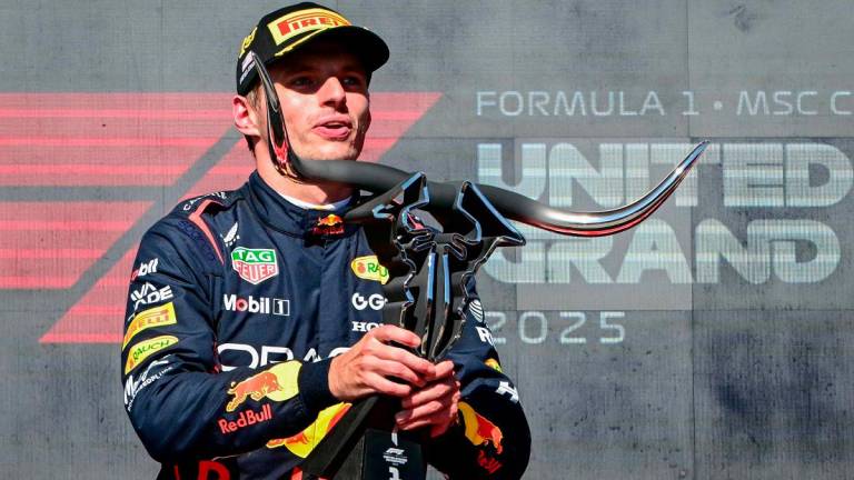 Red Bull Racing’s Dutch driver Max Verstappen hoists the trophy on the podium after winning the United States Formula One Grand Prix at the Circuit of the Americas in Austin, Texas, on October 19, 2025. - Jim WATSON / AFP