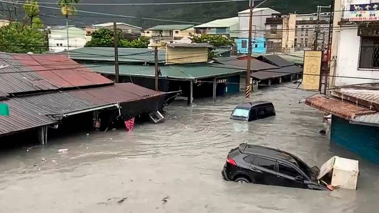 A car is seen stuck in floodwaters in Hualien on September 23, 2025, after a barrier lake burst and flooded the Guangfu township. AFP PHOTO / Taiwan’s Central News Agency (CNA)