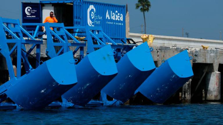 Floaters are raised out of the water during a demonstration of Eco Wave Power electricity generation technology using the power of ocean waves in the harbor at AltaSea at the Port of Los Angeles in San Pedro, California, on August 26, 2025. (Photo by Patrick T. Fallon / AFP)