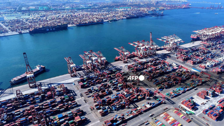 Containers and ships are seen at the port in Qingdao, in China’s eastern Shandong province on July 28, 2025. - AFP