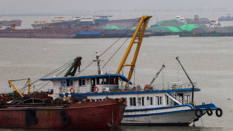 A tourist boat (in white) that capsized in an accident which killed dozens and left several people still missing, is towed back to the port in Halong Bay, Quang Ninh province, Vietnam, July 20, 2025. - REUTERS