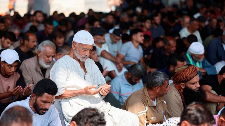 Palestinian Muslim worshippers attend friday prayers amidst the rubble of the destroyed Albaani Mosque in Khan Yunis in the southern Gaza Strip on October 17, 2025. - AL-QATTAA / AFP