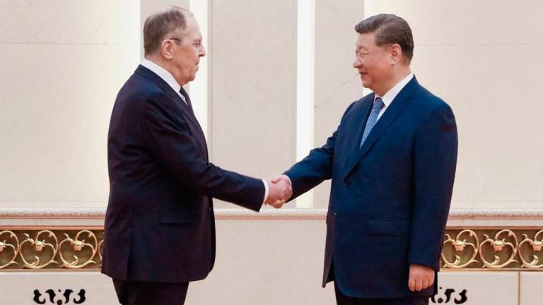 This handout photograph released by the Russian Foreign Ministry shows China’s President Xi Jinping (R) shaking hands with Russian Foreign Minister Sergey Lavrov in Beijing on July 15, 2025. - AFP PHOTO / HANDOUT / RUSSIAN FOREIGN MINISTRY