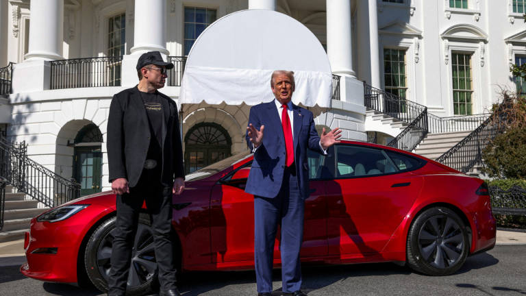 U.S. President Donald Trump talks to the media next to Tesla CEO Elon Musk, at the White House in Washington, D.C., U.S., March 11, 2025. - REUTERS