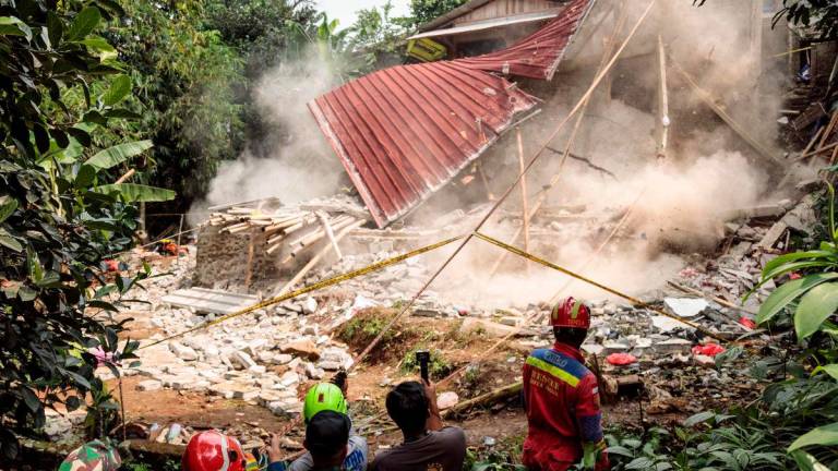 Rescue teams pull down unstable remains of a community Islamic study hall building with ropes after it collapsed while female Muslims were conducting studies to commemorate the birthday of the Prophet Muhammad, in Bogor, West Java, on September 7, 2025. According to the Regional Disaster Management Agency (BPBD), three women were killed and 65 others injured as rescue teams from the agency, police, army and volunteers responded. (Photo by ADITYA AJI / AFP)