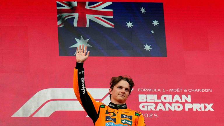 Winner McLaren’s Australian driver Oscar Piastri waves on the podium after the Formula One Belgian Grand Prix at the Spa-Francorchamps circuit in Spa, on July 27, 2025 - Photo by Dimitar DILKOFF / AFP
