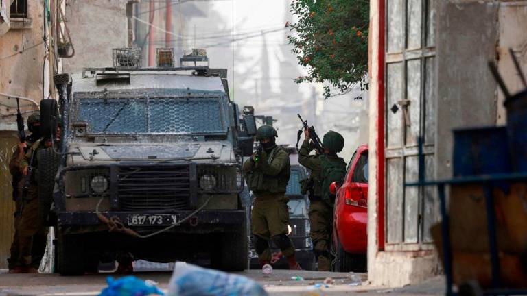 An Israeli soldier aims his weapon during a raid at the Balata refugee camp east of Nablus city in the occupied West Bank on August 11, 2025. - Jaafar ASHTIYEH / AFP