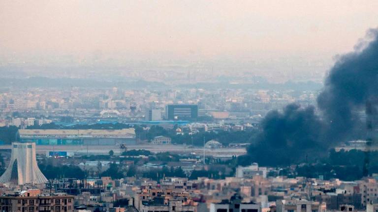 Smoke billows from a site near the Azadi Tower (L) in central Tehran, as fighting between Israel and Iran continues on June 16, 2025. Israel and Iran traded deadly fire on June 16 in their most intense confrontation in history, fuelling fears of a drawn-out conflict that could engulf the Middle East. - ATTA KENARE / AFP