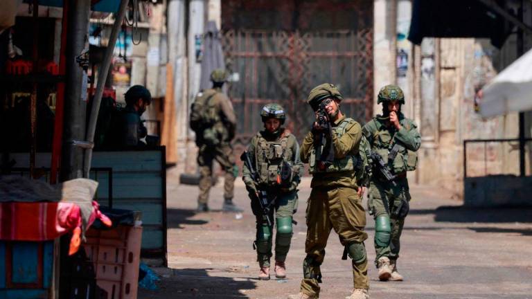 Israeli soldiers take aim during a raid in the old town of Nablus city in the occupied West Bank on June 10, 2025. (Photo by Jaafar ASHTIYEH / AFP)