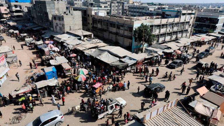 Palestinians shop at a market, amid a ceasefire between Israel and Hamas, in Khan Younis, southern Gaza Strip, October 20, 2025. REUTERS/Ramadan Abed