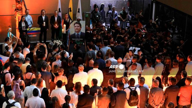 Medellin Mayor Federico Gutierrez (3nd L) and governor of Antioquia Andres Julian Rendon (4nd L) hold candles during a vigil for the death of Colombian presidential candidate Miguel Uribe at the Antioquia governor's office in Medellin, Colombia on August 11, 2025. - JAIME SALDARRIAGA / AFP