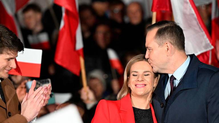 Karol Nawrocki (R), candidate for the 2025 Polish presidential election supported by Poland’s right-wing Law and Justice (PiS) party, kisses his wife Marta (C) as his son Daniel (L) applauds during a campaign rally in Stalowa Wola on May 16, 2025, ahead of the first round of the May 18 presidential elections