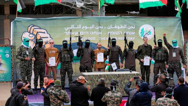 Or Levy, Eli Sharabi and Ohad Ben Ami, hostages held in Gaza since the deadly October 7, 2023 attack, are released by Hamas militants as part of a ceasefire and a hostages-prisoners swap deal between Hamas and Israel in Deir Al-Balah in the central Gaza Strip - REUTERSpix