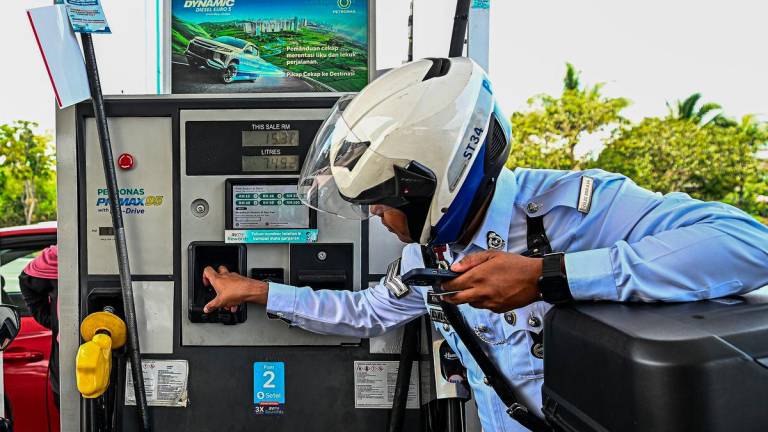 Anggota Penguatkuasaan Trafik IPD Seremban Mohammad Khidir Mohammad Shamsuri membuat bayaran menggunakan papan kekunci yang telah tersedia bagi menggunakan petrol RON95 di stesen Petronas S2 City Park pada harga RM1.99 seliter, berbanding harga pasaran RM2.05 seliter, menerusi inisiatif BUDI MADANI RON95 (BUDI95) yang bermula hari ini. - fotoBERNAMA