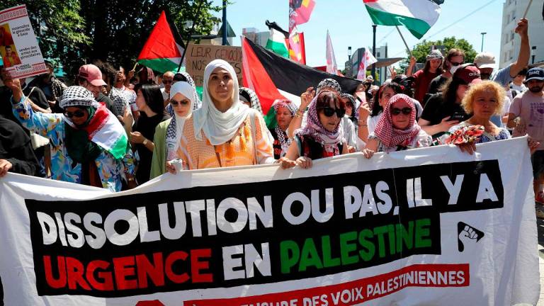 Protestors hold Palestinian flags and a banner reading “Dissolution or not, there is an emergency in Palestine. Stop the censorship of Palestinian voices” during a demonstration called by “War on War” collective against “war economy” and “death business” on the sideline of the 55th edition of the International Paris Air Show at the Paris–Le Bourget Airport, in Bobigny, a surburb of Paris on June 21, 2025. - ROMAIN PERROCHEAU / AFP