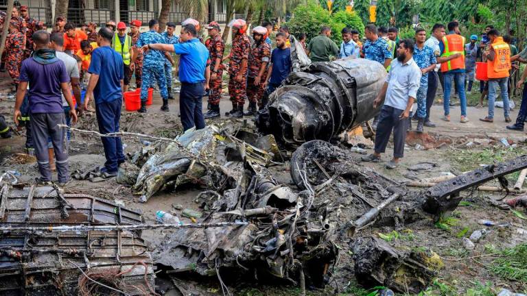Bangladesh’s fire service and security personnel conduct a search and rescue operation after an Air Force training jet crashed into a school in Dhaka - AFPPix