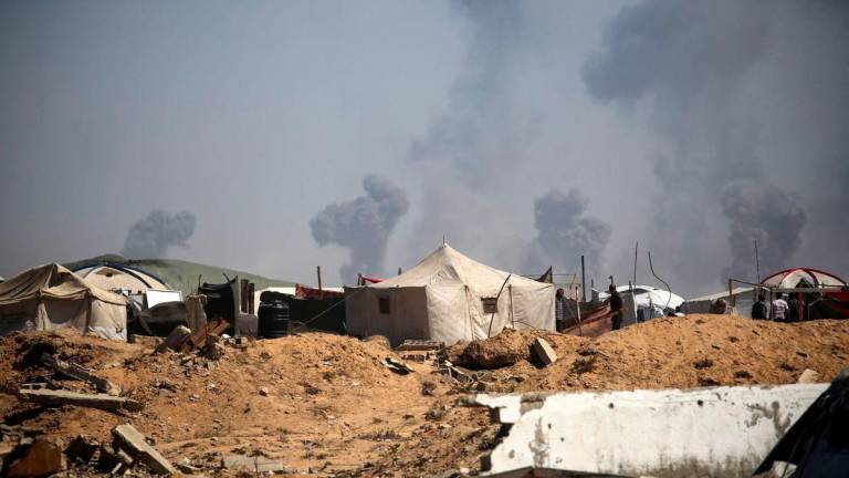 Tents of displaced Palestinians stand in the Nuseirat refugee camp in the central Gaza Strip, as plumes of smoke rise during Israeli bombardment above Gaza City, on September 19, 2025. (Photo by Eyad BABA / AFP)