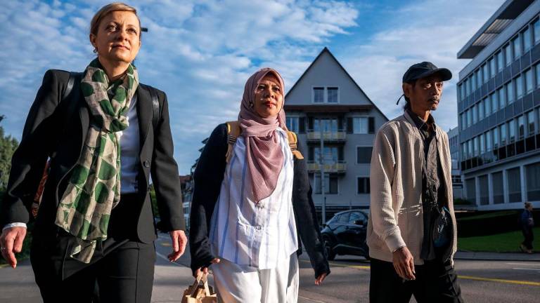 Indonesian plaintiffs Ibu Asmania (C) and Arif Pujianto (R) arrive with their Swiss lawyer Cordelia Baehr (L) for a first hearing in the climate lawsuit filled by four Indonesians of the island of Pari, against the cement giant Holcim, in Zug central, Switzerland, on September 3, 2025. - Fabrice COFFRINI / AFP